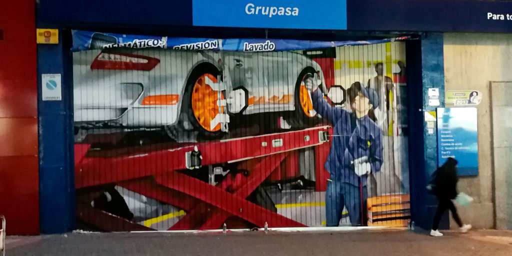 Graffiti en cierre de taller mecánico en Usera
