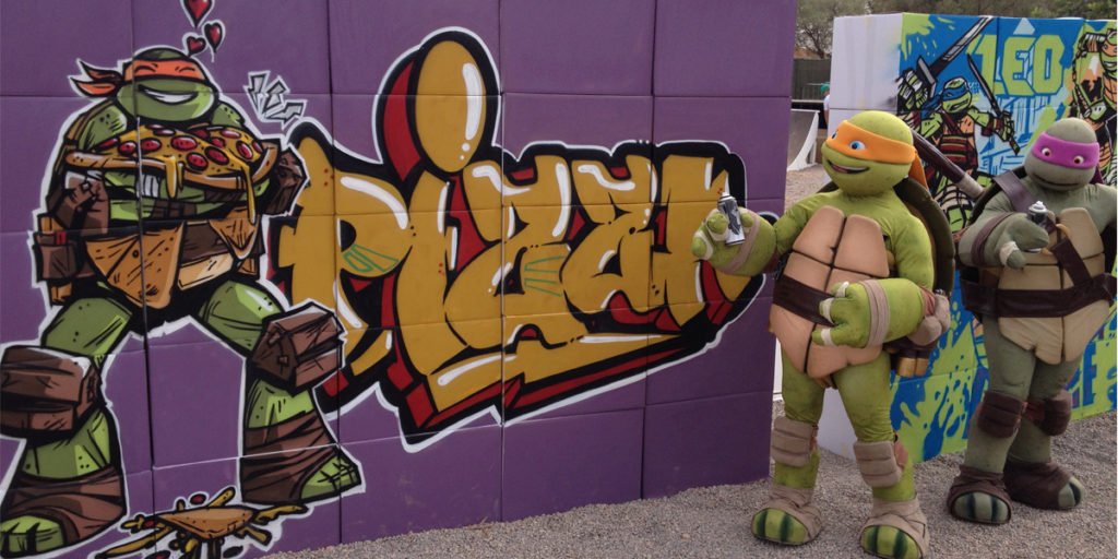 Tortugas-ninja-con-graffiti-en-evento Tortuga Ninja junto a graffiti en evento.