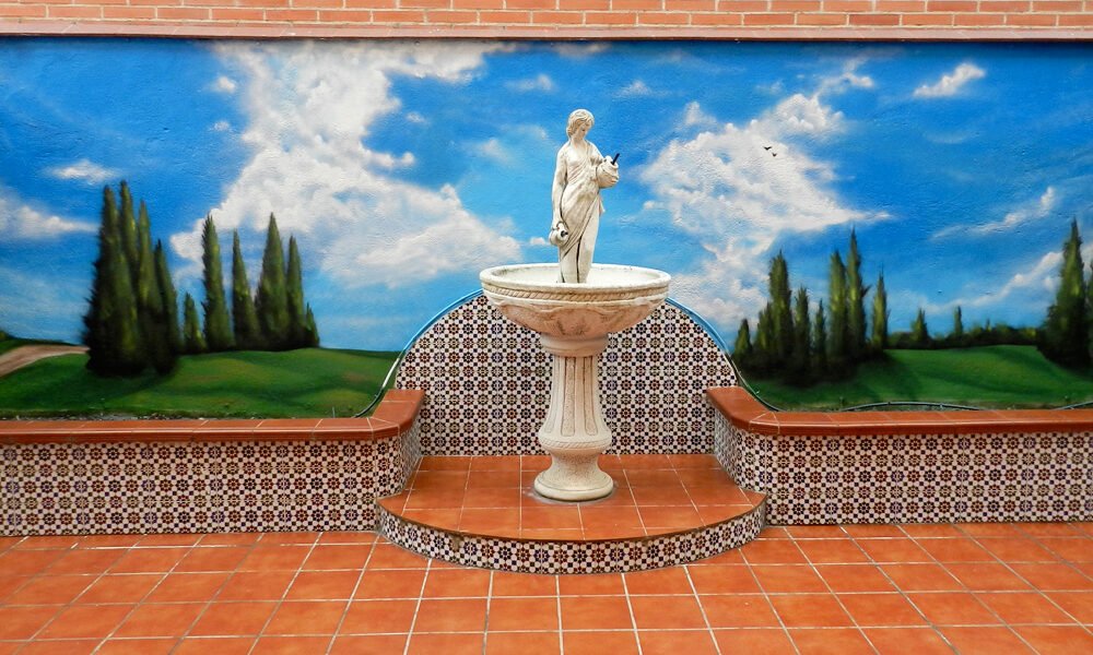 graffiti-en-patio-con-paisaje Graffiti en patio con escultura