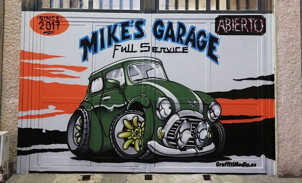 Graffiti de coche en puerta de taller mecánico